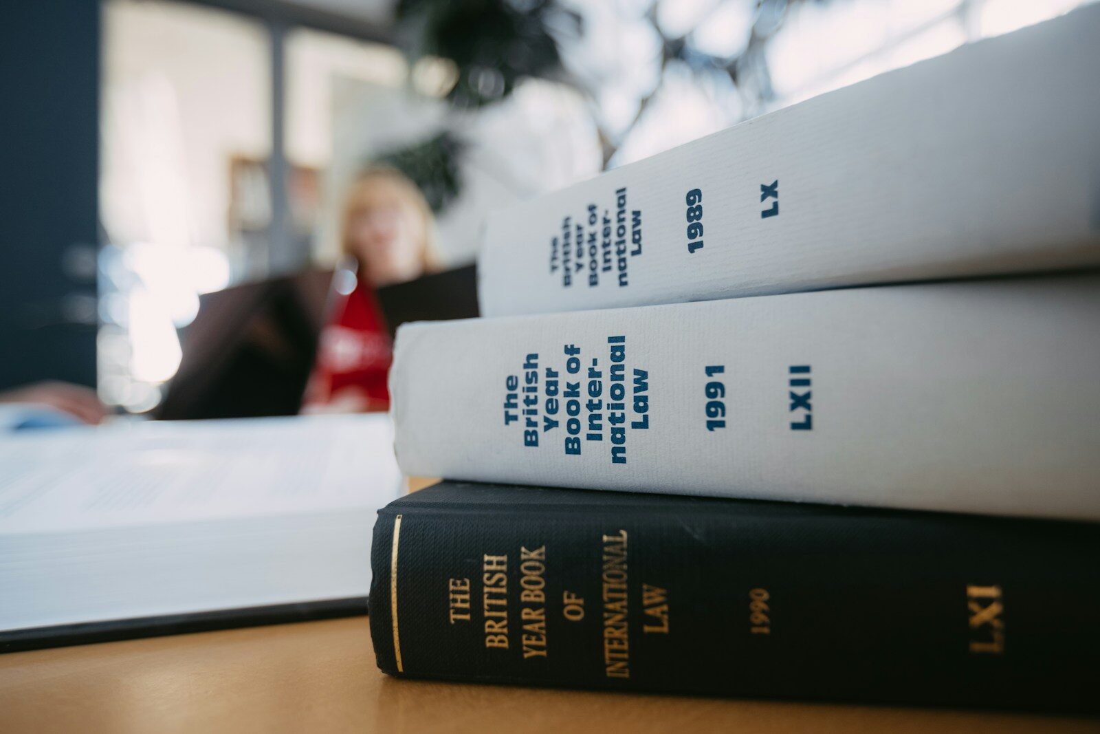 Legal books are stacked on a desk.