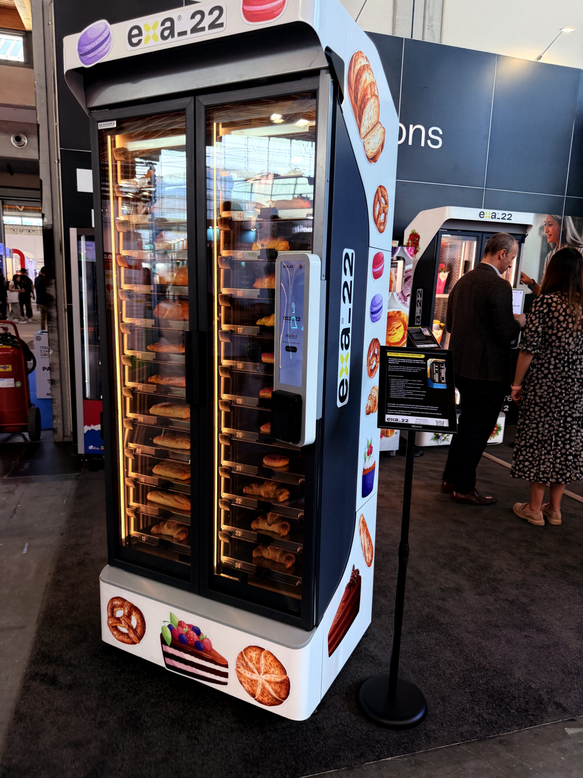 Bakery vending machine with glass front and lit compartments holding bread and pastries