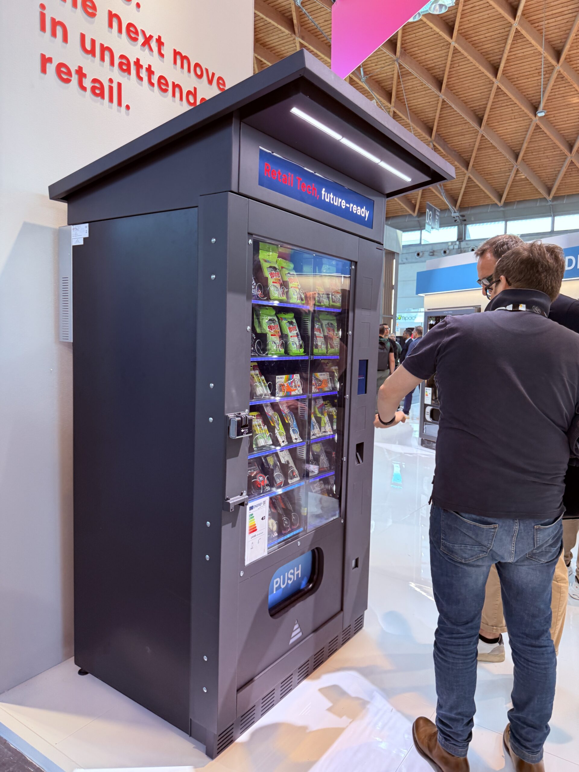 Outdoor vending machine positioned beside a building entrance